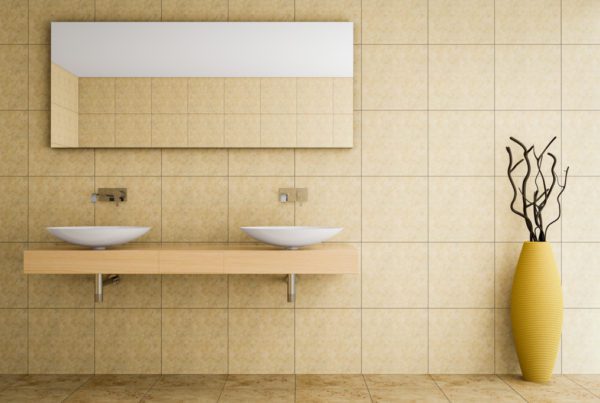 [health] Yellow ceramic tile installed in a bathroom with decorative plant in a standing vase to the right of it.